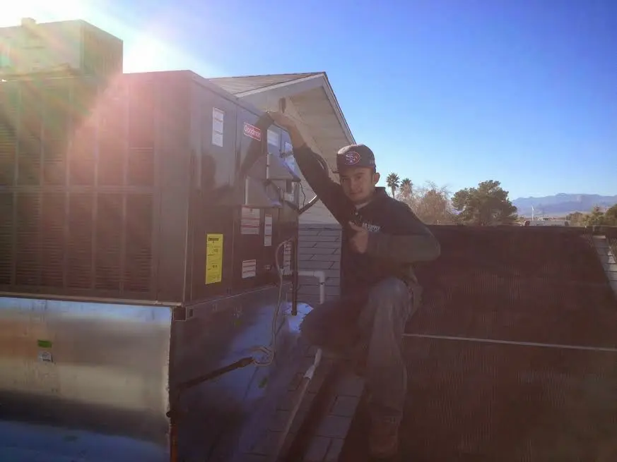 HVAC technician performing Heat Pump Repair on a rooftop unit in Ripon